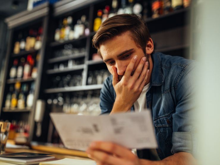 uomo preoccupato che legge bolletta