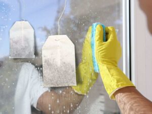 bustine di tè e persona che pulisce vetro